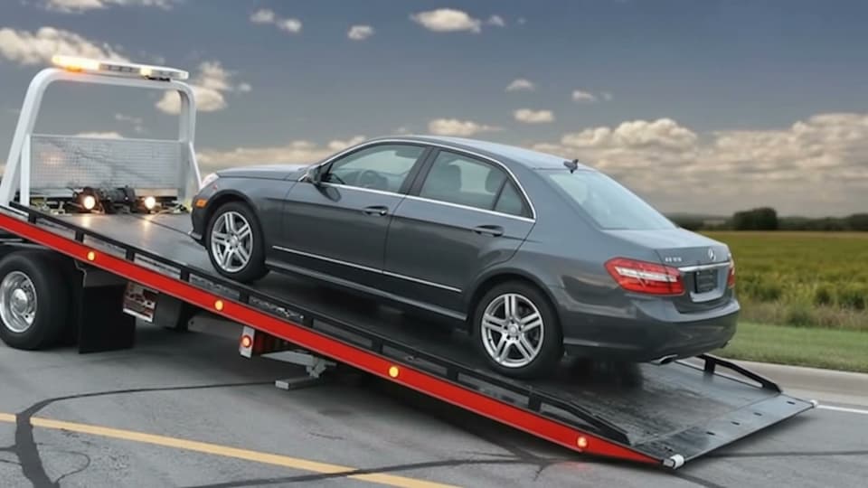 Arkadan görünüm: sedan otomobil eğimli kasa üzerinde yukarı çekiliyor